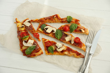 Sliced tasty pizza on parchment