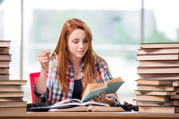 Student with stacks of books preparing for exams