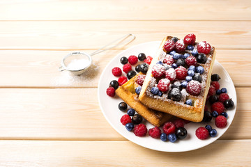 Breakfast waffles with fresh berries and powder sugar