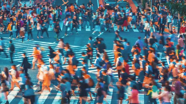 People and vehicles cross the famous Shibuya intersection in Tokyo in time lapse. The Shibuya scramble crosswalk is one of the busiest intersections in the world.