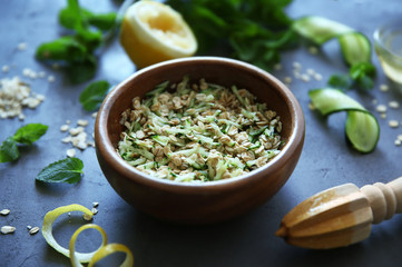 Natural scrub of oatmeal, olive oil, cucumber, mint and lemon on table