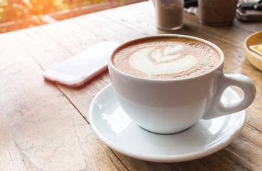 Coffee cup and mobile phone on wood table background, fillter ef