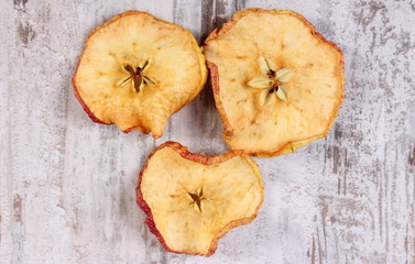 Slices of dried apple on old rustic wooden background
