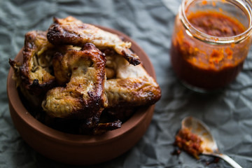 Chicken Wings in a bowl with tomato sauce.