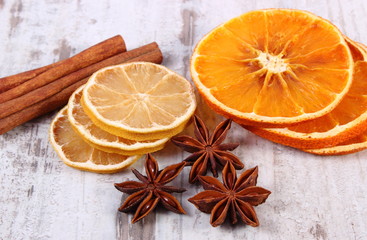 Fototapeta na wymiar Slices of dried lemon, orange and spices on old wooden background