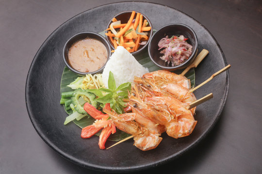 Skewered prawns with a portion of white rice