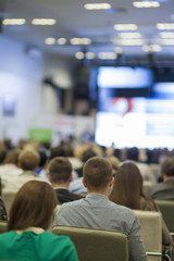 Large Group of People in Congress Hall Watching Presentation Charts on Screen