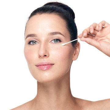 Woman removes makeup from the face with a cotton swab. Happy bea