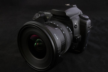 Fototapeta premium One black camera with wide angle lens isolated on black backgrou