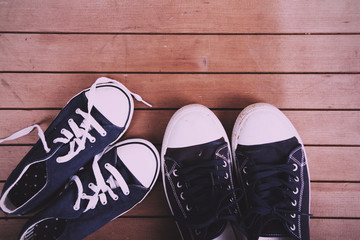 Old canvas shoes on a wooden floor Vintage Retro Filter.