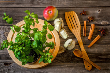 still life of wooden utensils with mint and apples