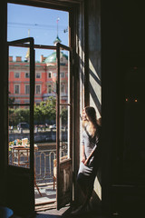 woman standing and a balcony with views of the Saint-Petersburg