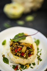 Pattison stuffed with barley groats with vegetables and herbs served on a plate on a stone table. Vegetarian food.