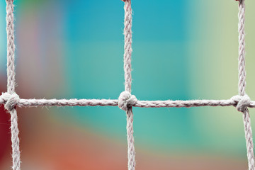 Fencing from ropes with knots on the colorful background. Closeup