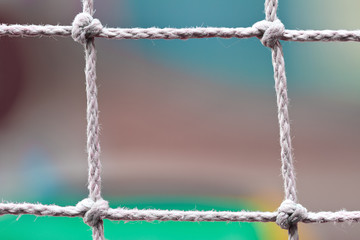 Fencing from ropes with knots on the colorful background. Closeup