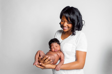 African American Newborn Reclining On Mother