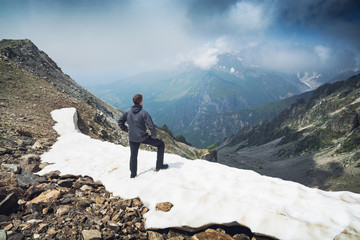 Hiker stays on a snow mountain hill