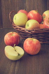 Apples in basket on wooden rustic background