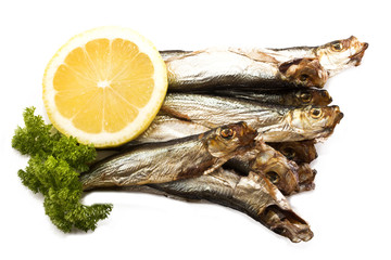 smoked sprats with lemon and parsley on bright background