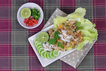 Fried rice with crab topped streamed crab,halve green lemon,sliced cucumber,lettuce and coriander  served  spicy  sour filling side dish.  Top view 