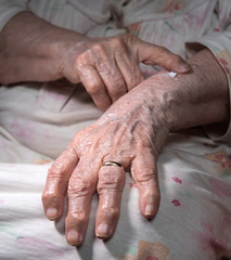Fototapeta premium Old woman applying hand cream