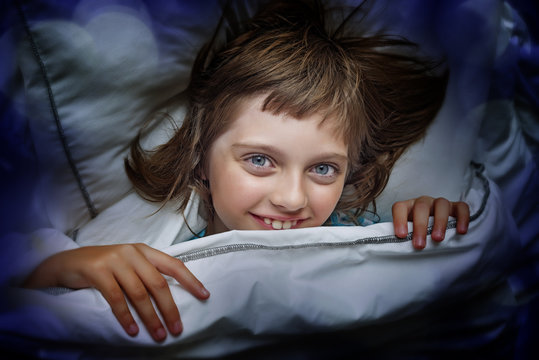 happy little girl resting in a bed