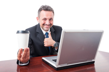 Business man at office holding coffe showing thumb up