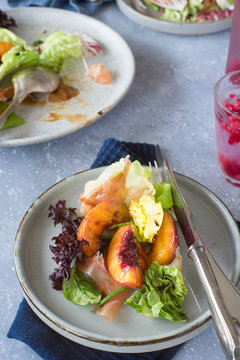 Mixed green salad with prosciutto and grilled nectarine slices.