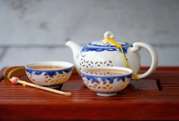 kettle and two bowls of blue and white color with green tea