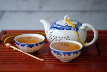 kettle and two bowls of blue and white color with green tea