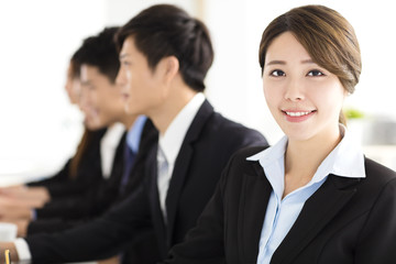Smiling businesswoman looking at camera with  colleague