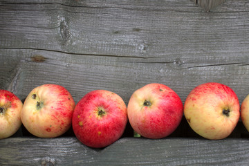 Sweet juicy fresh red apples on the old gray wooden table. Wooden Rustic autumn backdrop