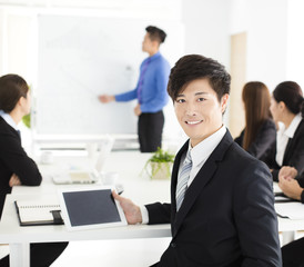 Fototapeta premium Smiling businessman looking at camera with colleague