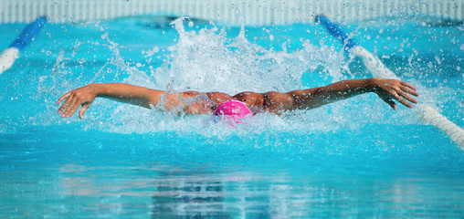 Man swims the butterfly in the pool