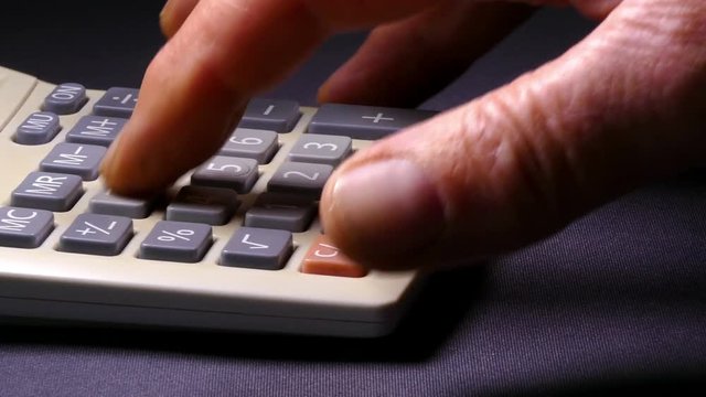Slider shot across a man&rsquo;s hand using a calculator.