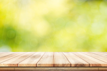 Empty wooden  table with foliage bokeh background. Ready for product display montage.