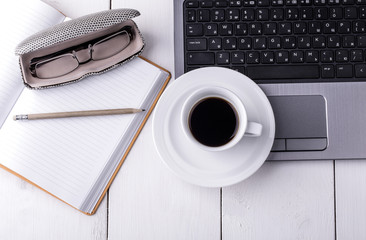 laptop, notebook with a cup of coffee and a pencil