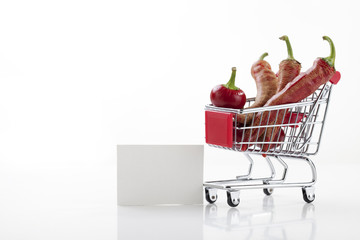 Red hot chili peppers in supermarket trolley isolated on white