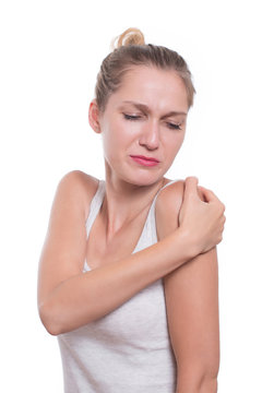 Acute pain in a woman shoulder. Female holding hand to shoulder