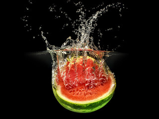 Fresh melon falling in water with splash on black background