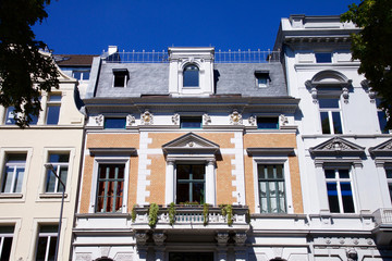 Historic Renaissance Revival architecture in the Frankenberger Quarter, Aachen, Germany with townhouses with ornate stone carving and dormer windows against a blue sky