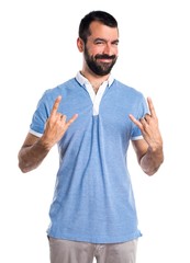 Man with blue shirt making horn gesture