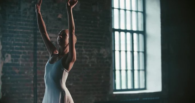 beautiful girl dancer performs elements of classical ballet in the loft design Studio,slow motion