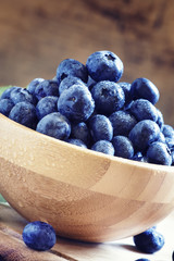 Autumn blueberries in wooden bowl, selective focus