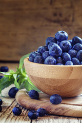 Autumn blueberries in wooden bowl, selective focus