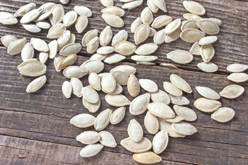 Toasted pumpkin seeds on wooden background