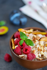 Oatmeal with berries, plums, nuts and honey for breakfast