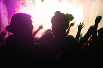 Silhouettes of happy people infront of a stage