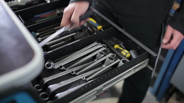 Mechanic takes screwdriver from tool box