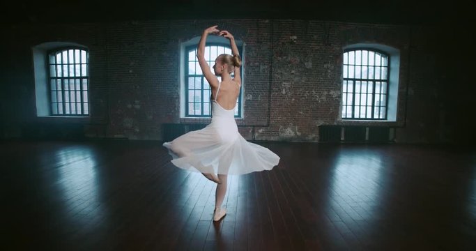 beautiful girl dancer performs elements of classical ballet in the loft design Studio,slow motion